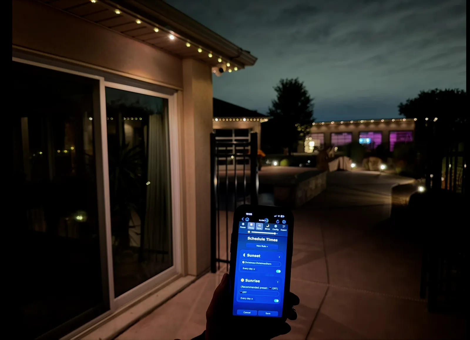 Lighting app schedule screen on a phone, with soffit lights on a patio at night