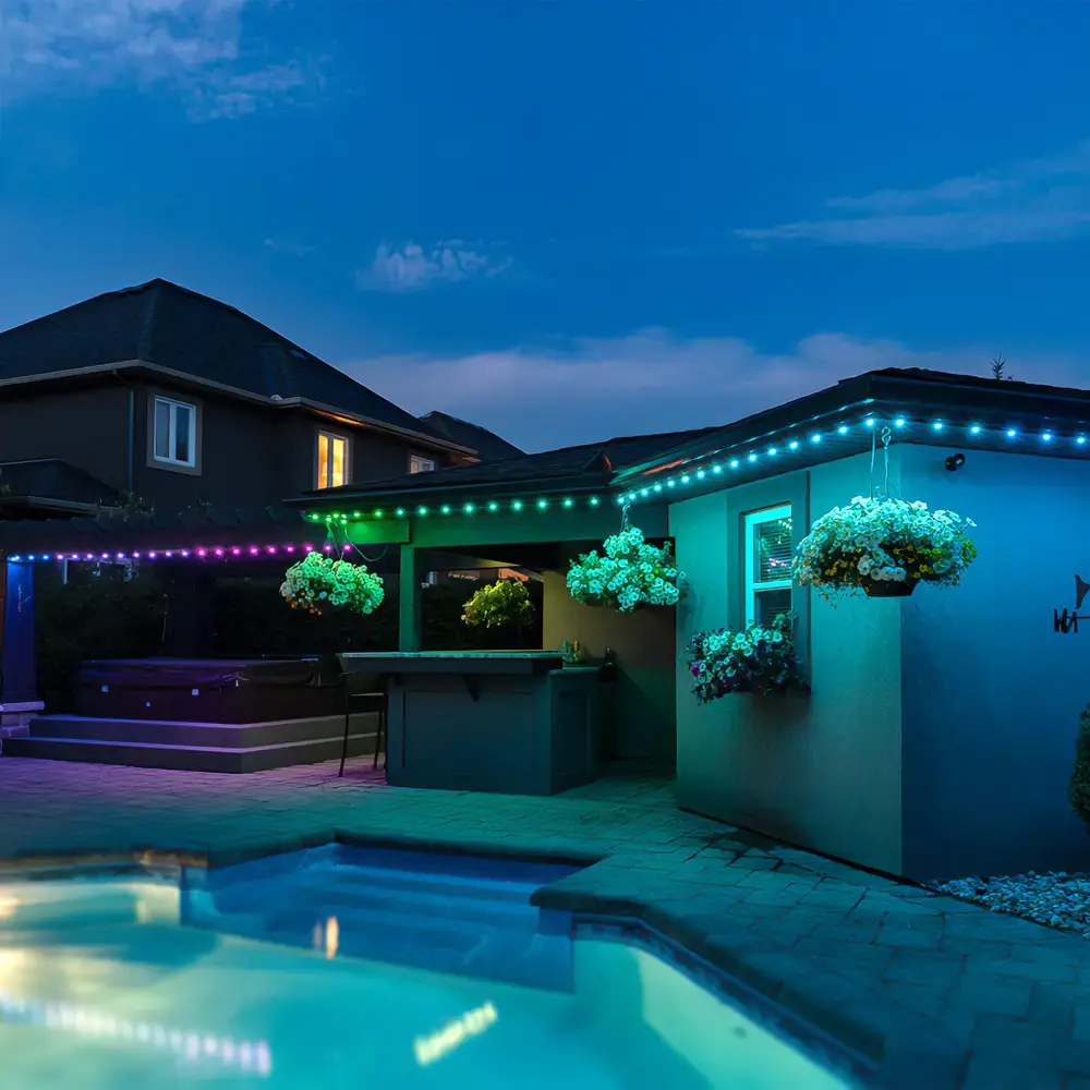 Multicolour permanent lighting around a backyard pool and cabana at dusk