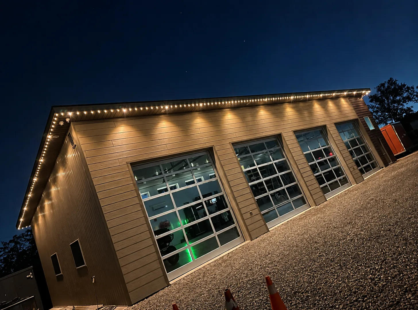 Soffit lighting along a detached garage with glass overhead doors