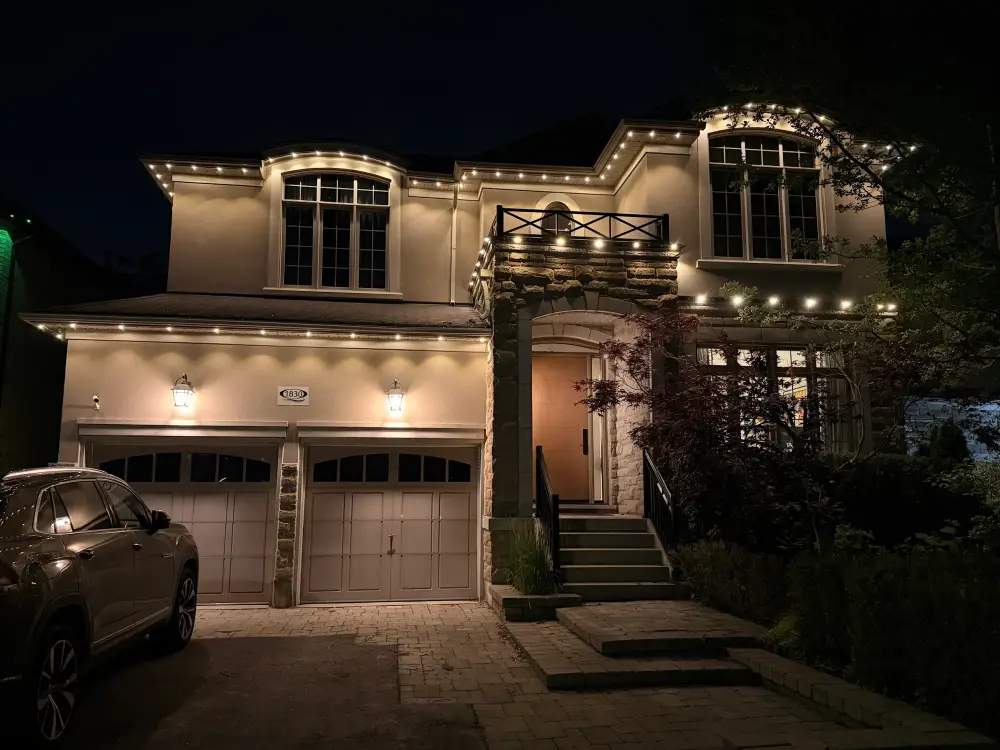Warm white accent lighting on a two-storey stucco home at night