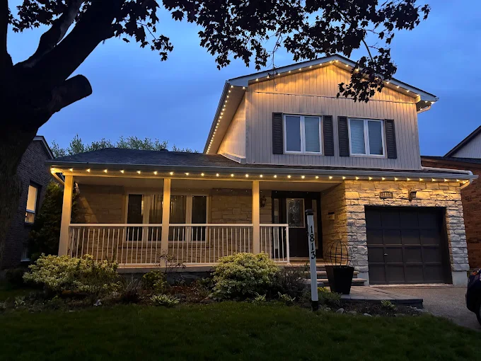 Warm white accent lighting on a split-level home at dusk